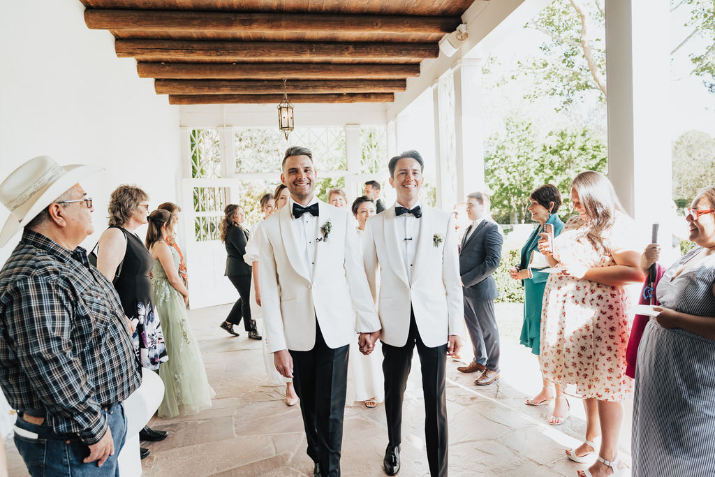 Joe (left) and Isaac (right) walking hand and hang by their guests on their way to the ceremony.