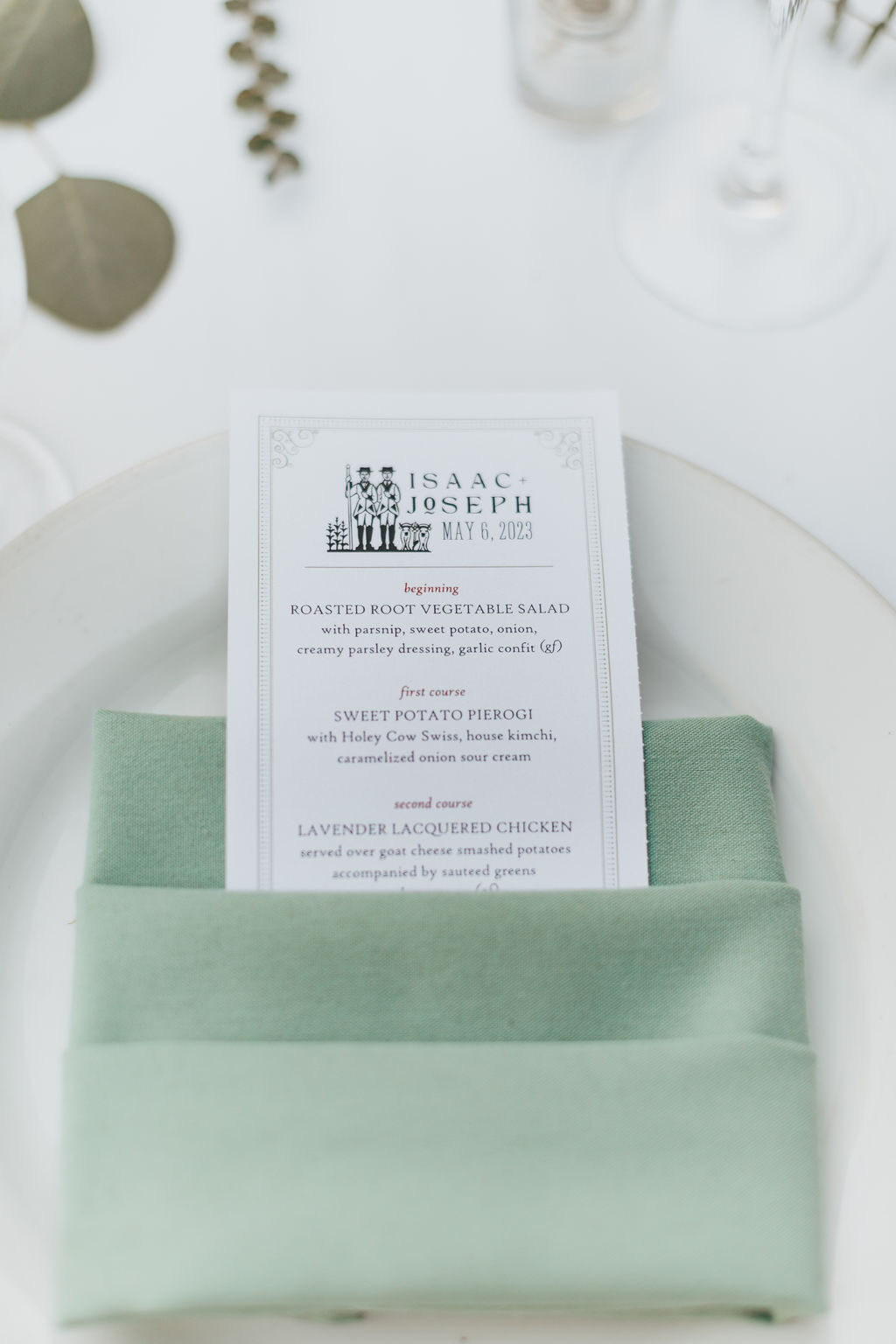 Dinner menu on table on top of white plate and green napkin.